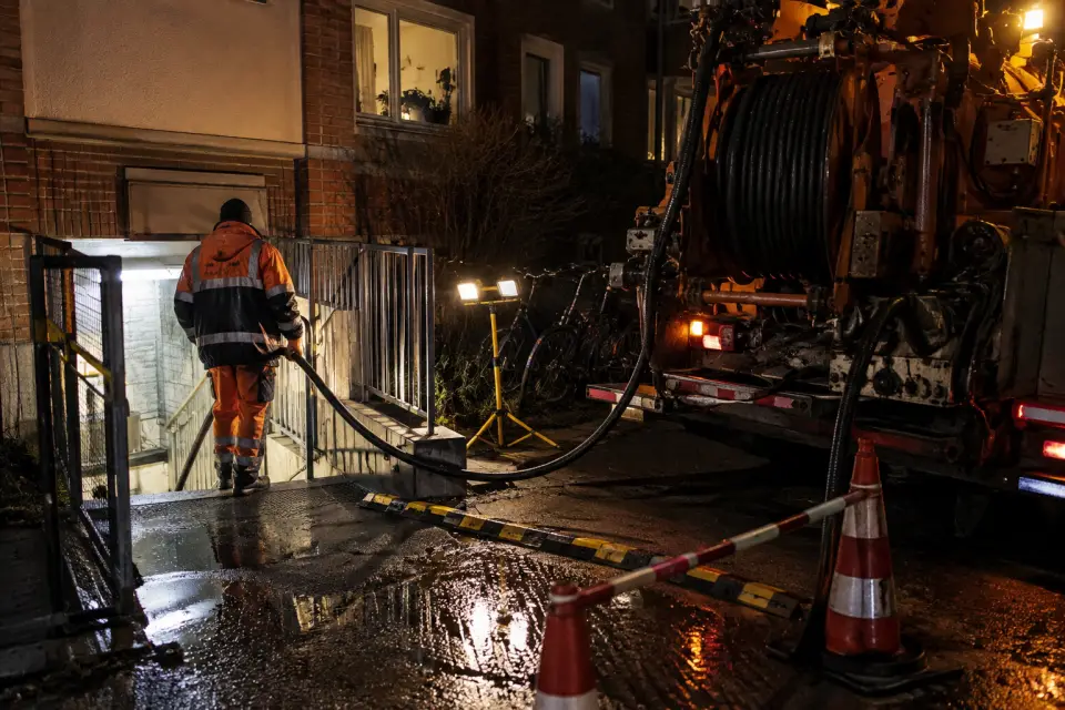Gesicherter Kellerzugang mit Spülschlauch und Arbeitsleuchte bei einem nächtlichen Rohrnotdienst in Hamburg